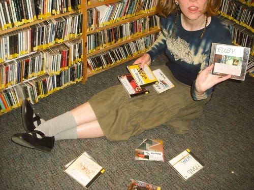 Animatrice qui montre les notes sur les CD des programmateurs historiques de la radio étudiante