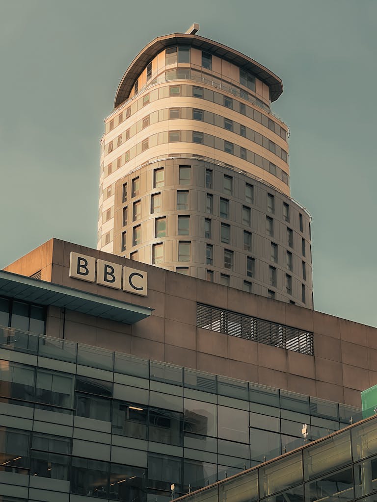Glass and concrete architecture of BBC skyscraper in Manchester under a clear sky.